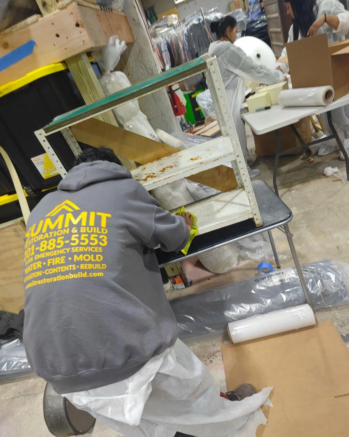 Summit crew member in a branded hoodie working at a contents processing station